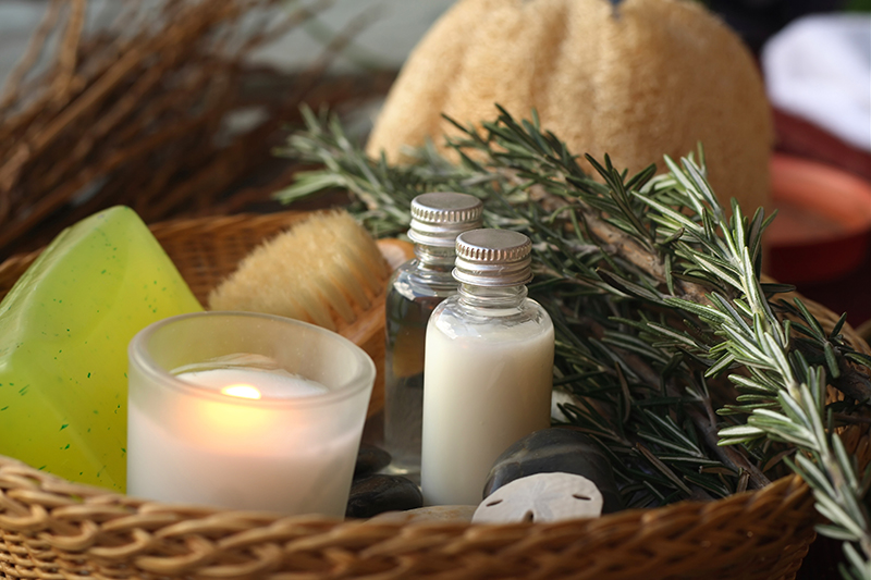 "Candle-lit spa items: exfoliating brush, massage oil, soap, rosemary, loofah...You may also like:"